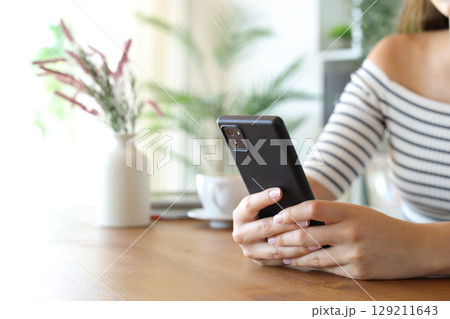Woman hand throwing sugar in a coffee cup at home 129211643