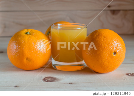 Orange is placed next to a glass of refreshing drink Orange is placed next to a glass of refreshing drink 129211940