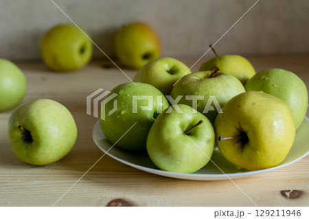 Green juicy apples on the table 129211946