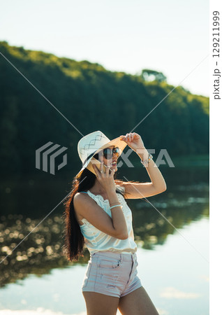 A young girl in shorts, a T-shirt and a hat A young girl in shorts, a T-shirt and a hat 129211999
