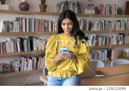 Young Indian woman, office employee or university student using smartphone 129212099
