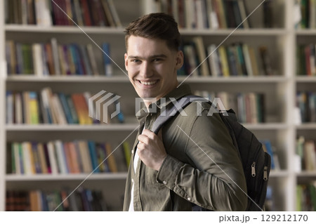 Smiling motivated student guy with stylish backpack looking at camera 129212170