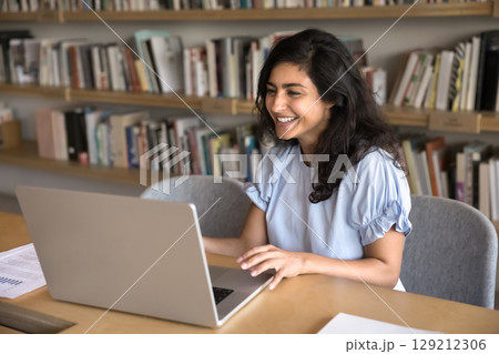 Happy Indian woman reading good professional news on laptop Happy Indian woman reading good professional news on laptop 129212306