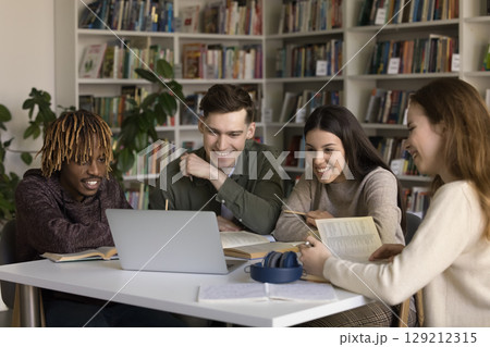 Multiethnic gen z students use notebook in library for studying Multiethnic gen z students use notebook in library for studying 129212315