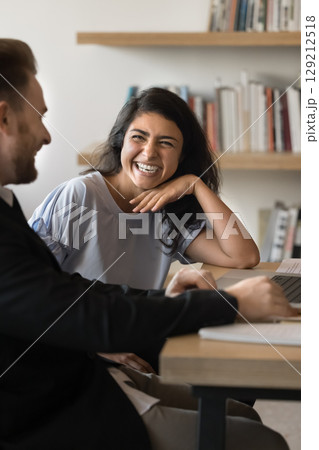 Happy Indian woman laughing during meeting with male colleague 129212518