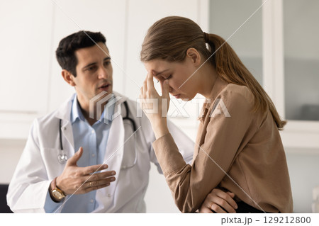 Shocked female patient getting bad news from doctor Shocked female patient getting bad news from doctor 129212800