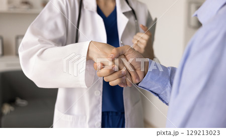 Female GP doctor shaking hands with male patient Female GP doctor shaking hands with male patient 129213023