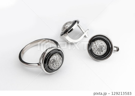 Silver jewelry set of ring and silver earrings with stones on white background. Silver jewelry set collection Silver jewelry set of ring and silver earrings with stones on white background. Silver jewelry set collection 129213583