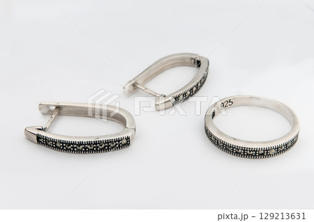 Silver jewelry set of ring and silver earrings with stones on white background. Silver jewelry set collection 129213631