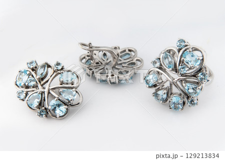 Elegant jewelry set of white gold ring, necklace and earrings with diamonds. Silver jewellery set with gemstones. Product still life concept Elegant jewelry set of white gold ring, necklace and earrings with diamonds. Silver jewellery set with gemstones. Product still life concept 129213834