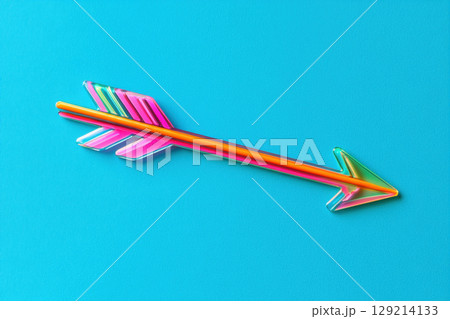 Vibrant multicolored arrow lying diagonally on bright blue textured background with modern geometric design and glossy finish, AI Generative 129214133