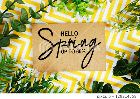 Hello Spring Sale 80% off with artificial leaf decoration on yellow chevron background 129214359
