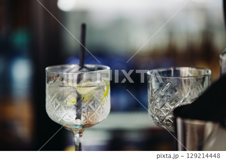 A glass with an unfinished drink in a wine glass at a beach cafe A glass with an unfinished drink in a wine glass at a beach cafe 129214448