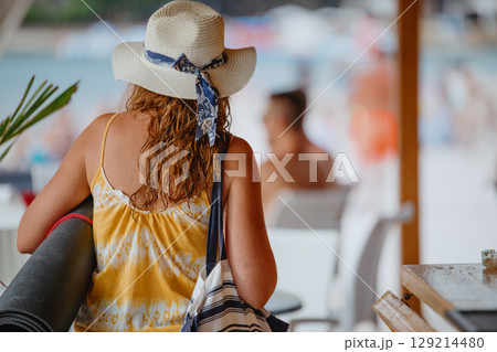 Unrecognizable young woman in light dress with yoga mat in hat and canvas bag Unrecognizable young woman in light dress with yoga mat in hat and canvas bag 129214480