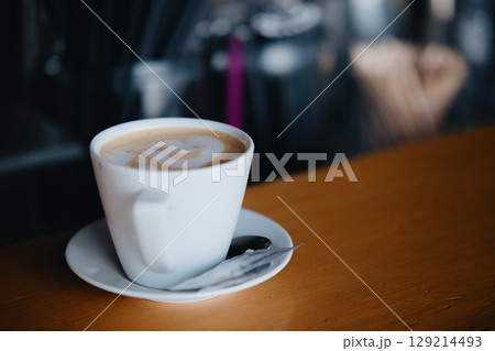 A cup of cappuccino with a smiley latte art awaits visitors at the bar. Ordering 129214493