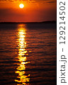 Romantic sunset and sky with calm sea with slight ripples in the background 129214502