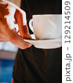Waiter of summer beach cafe brings cup of coffee to customer. Summer relaxation 129214509