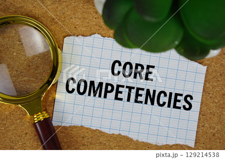 Core Competencies text written on paper with magnifying glass 129214538