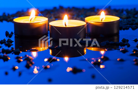 Small candles on a blue background look especially tender 129214571
