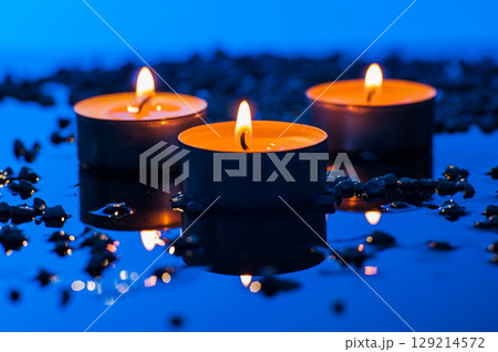 Small candles on a blue background look especially tender 129214572