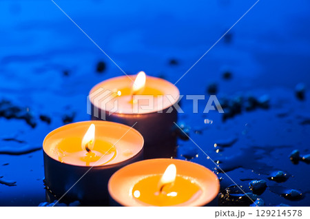 Three tealight candles emit a soft light that fills the frame with warmth Three tealight candles emit a soft light that fills the frame with warmth 129214578