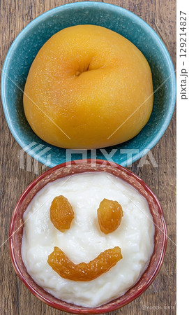 Cheerful Fruit and Rice Pudding Face for a Happy Meal. 129214827
