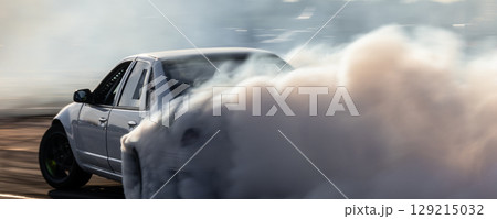 Car drifting, Blurred image diffusion race drift car with lots of smoke from burning tires on speed track, Car drifting on speed track, Professional driver drive drifting car. 129215032