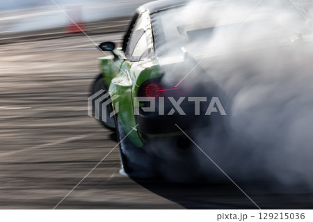 Car drifting, Blurred image diffusion race drift car with lots of smoke from burning tires on speed track, Car drifting on speed track, Professional driver drive drifting car. Car drifting, Blurred image diffusion race drift car with lots of smoke from burning tires on speed track, Car drifting on speed track, Professional driver drive drifting car. 129215036