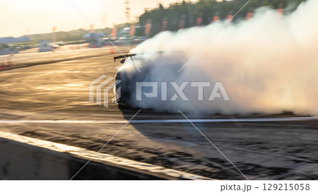 Car drifting, Blurred image diffusion race drift car with lots of smoke from burning tires on speed track, Car drifting on speed track, Professional driver drive drifting car. Car drifting, Blurred image diffusion race drift car with lots of smoke from burning tires on speed track, Car drifting on speed track, Professional driver drive drifting car. 129215058