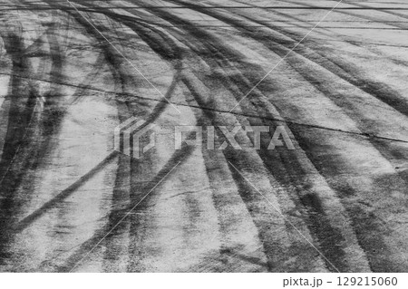 Black tire marks on road, Black rubber tire marks and tread marks, Tire trace track wheels texture and background, Auto tire tread grunge, Car wheel tyre tread track black tyre print, Aerial view. Black tire marks on road, Black rubber tire marks and tread marks, Tire trace track wheels texture and background, Auto tire tread grunge, Car wheel tyre tread track black tyre print, Aerial view. 129215060