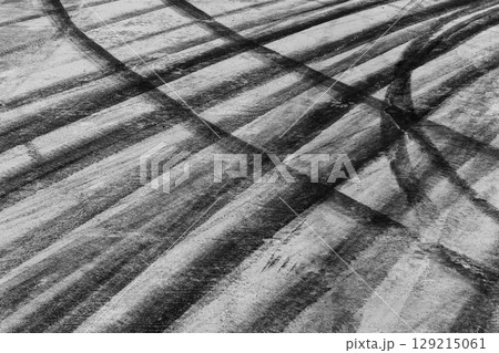 Black tire marks on road, Black rubber tire marks and tread marks, Tire trace track wheels texture and background, Auto tire tread grunge, Car wheel tyre tread track black tyre print, Aerial view. Black tire marks on road, Black rubber tire marks and tread marks, Tire trace track wheels texture and background, Auto tire tread grunge, Car wheel tyre tread track black tyre print, Aerial view. 129215061