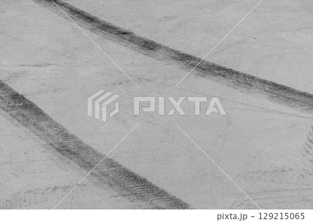 Black tire marks on road, Black rubber tire marks and tread marks, Tire trace track wheels texture and background, Auto tire tread grunge, Car wheel tyre tread track black tyre print, Aerial view. 129215065