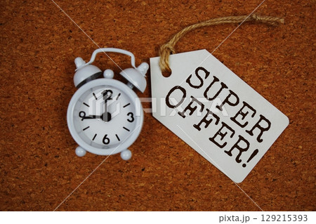 Super Offer! text on price tag with alarm clock on cork board background 129215393