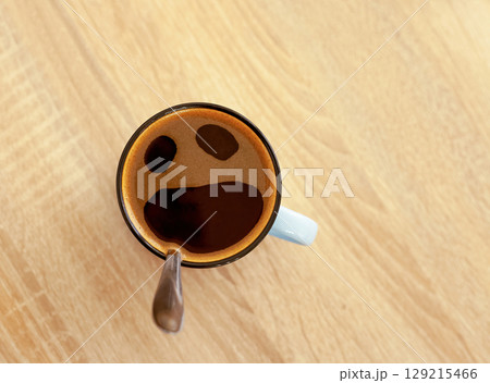 Coffee cup with funny screaming in fear face, top view. Pareidolia effect at breakfast Coffee cup with funny screaming in fear face, top view. Pareidolia effect at breakfast 129215466