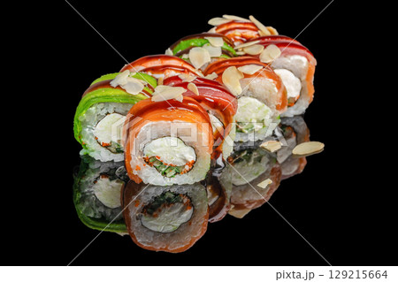 Colorful sushi rolls with salmon, tuna, avocado, cream cheese, and almond flakes arranged on a glossy black surface Colorful sushi rolls with salmon, tuna, avocado, cream cheese, and almond flakes arranged on a glossy black surface 129215664