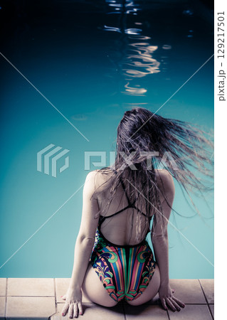 Woman back in swimsuit on pool edge. 129217501