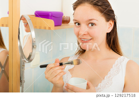 Woman applying mud facial mask Woman applying mud facial mask 129217518