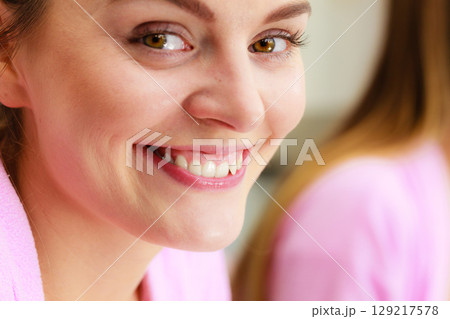 young woman looking at mirror in bathroom 129217578