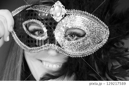 Woman holding carnival mask closeup Woman holding carnival mask closeup 129217589