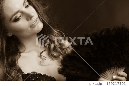 Woman holding carnival feather fan in hand. Woman holding carnival feather fan in hand. 129217591
