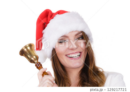 Woman in santa claus hat ringing a bell 129217721