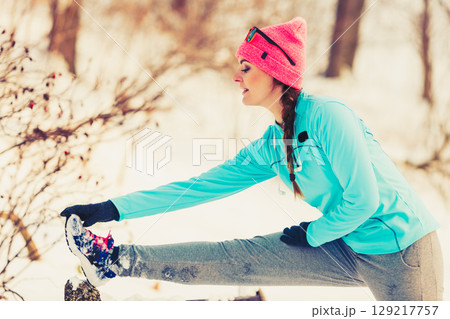 Girl stretching on bench in winter 129217757