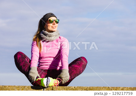 Woman resting after doing sports outdoors on cold day 129217759