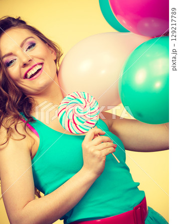 Woman with colorful balloons and lollipop Woman with colorful balloons and lollipop 129217789