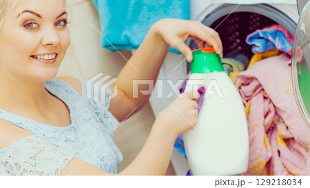 Girl doing laundry using liquid detergent 129218034