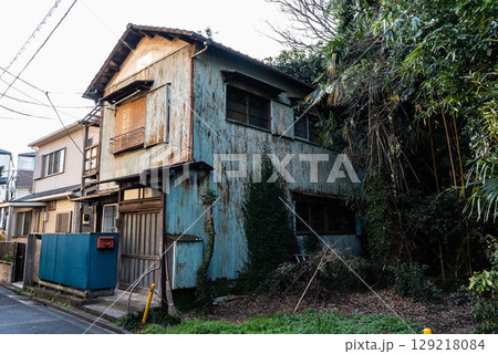 古い昭和建築、トタン作りの錆びた一軒家、鬱蒼とした二階建て狭小住宅 129218084