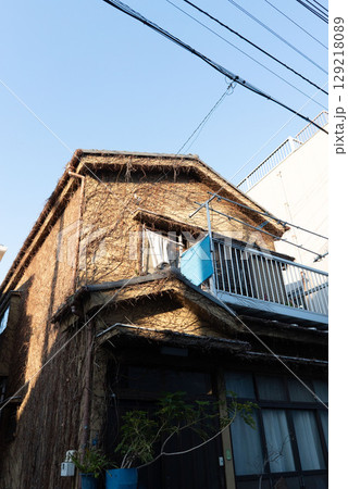 古い昭和建築、トタン作りの錆びた一軒家、鬱蒼とした二階建て狭小住宅 129218089