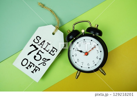 Sale 75% off text on price tag with alarm clock on green, yellow geometric background Sale 75% off text on price tag with alarm clock on green, yellow geometric background 129218201