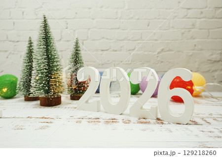 Happy New Year 2026 festive background with christmas tree on white brick wall background 129218260
