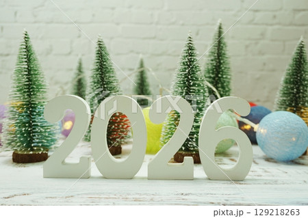 Happy New Year 2026 festive background with christmas tree on white brick wall background 129218263